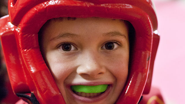 Une petite fille avec un casque et un protège-dents