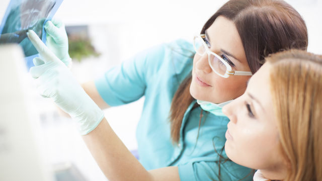 Dentiste montrant une radiographie à un patient